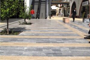 Nowoczesna ulica handlowa z kamienną nawierzchnią, roślinami i ludźmi - Metamar