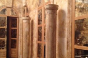 Wnętrze z drewnianymi ścianami, kolumnami i drzwiami.