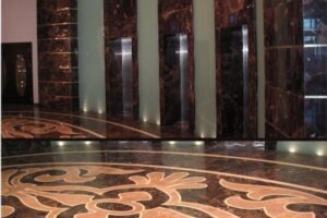 Marmurowa podłoga z ornamentami, ściana z marmuru, oświetlenie.