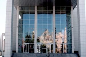 Budynek z dużymi oszklonymi oknami odbijającymi katedrę - Metamar