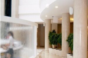 Nowoczesny hol z filarami, zielonymi roślinami i oświetleniem