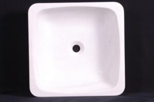 Biała kwadratowa umywalka z otworem odpływowym na czarnym tle - Metamar