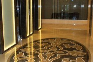 Eleganckiy hol z dekoracyjną posadzką, oświetleniem neonowym i szklanymi panelami.