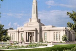 Biały neorządowy budynek z wieżą, otoczony zielenią i czystym niebem.