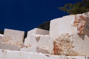 Białe bloki marmuru w kamieniołomie, błękitne niebo - Metamar