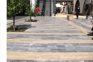 Nowoczesna passa handlowa z szarymi i beżowymi płytami, zielenią i ludźmi - Metamar