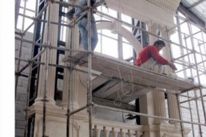 Pracownicy na rusztowaniu wewnątrz budynku w trakcie budowy - Metamar