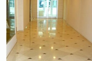 Pusty korytarz z błyszczącą posadzką i szklanymi drzwiami. - Metamar