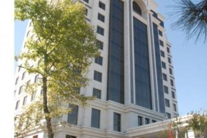 Nowoczesny budynek mieszkalny, biały z dużymi oknami, otoczony zielenią - Metamar