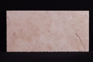 Jasny beżowy kamień trawertynu z plamami i pęknięciem