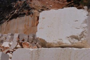 Kamieniołom marmuru z białymi blokami i czerwonawą ziemią - Metamar