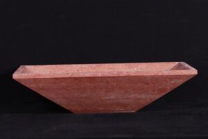 Terrakotowa miska o wydłużonym kształcie na czarnym tle