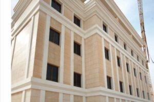 Nowoczesny budynek z beżowym kamienia i białymi detalami architektonicznymi - Metamar