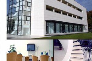 Nowoczesny budynek biurowy z białą fasadą, szklaną windą i tarasem zielonym - Metamar