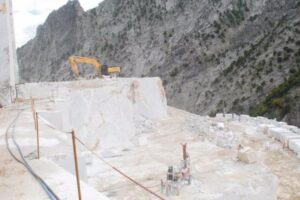 Kamieniołom marmuru u podnóża góry z koparka - Metamar