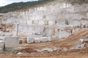 Kamieniołom z białym marmurem, wykopane bloki i maszyny.