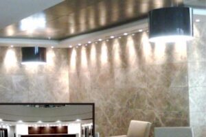 Nowoczesna kuchnia z metalicznym sufitem, oświetleniem LED i beżowymi ścianami - Metamar