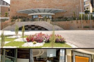 Nowoczesny budynek z cegły, ogrodzeniem i kwiatami. - Metamar