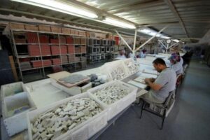 Pracownicy sortują ceramiczne przedmioty w hali produkcyjnej. - Metamar