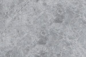 Szara marmurowa tekstura z naturalnymi żyłkami i plamami.