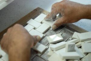 Ręce montujące białe przełączniki elektryczne w instalacji ściennej - Metamar