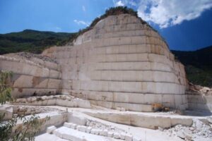 Kamieniołom marmuru z wielką ścianą bloków kamiennych i zielonymi wzgórzami - Metamar