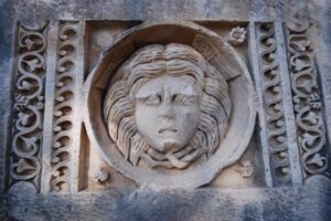 Kamienny relief głowy kobiety w medalionie z ornamentami - Metamar