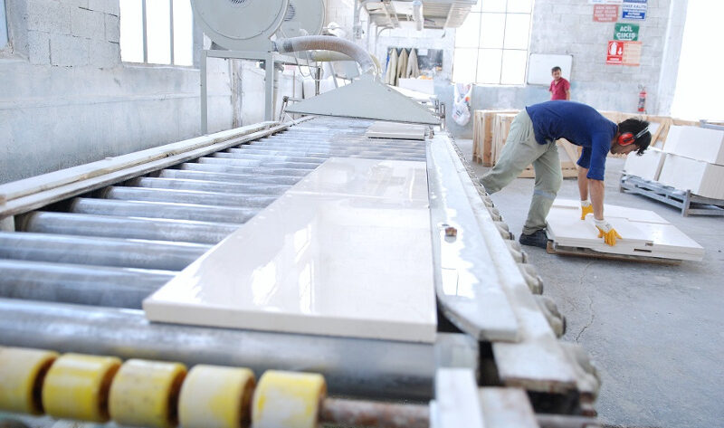 Pracownik w fabryce przy maszynie do obróbki materiałów – Metamar