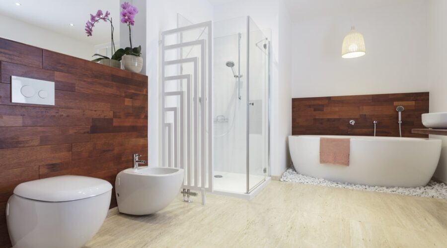 Nowoczesna łazienka z drewnianą ścianą, białą wanną i prysznicem - Metamar
